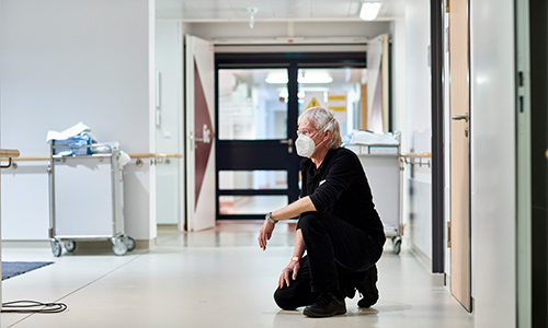 Fotograf Jörg kniet im Krankenhausflur